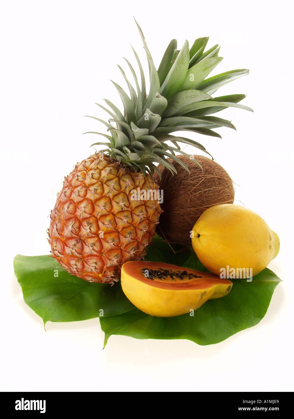 Pineapple papayas and coconut on palm leaf Stock Photo Alamy