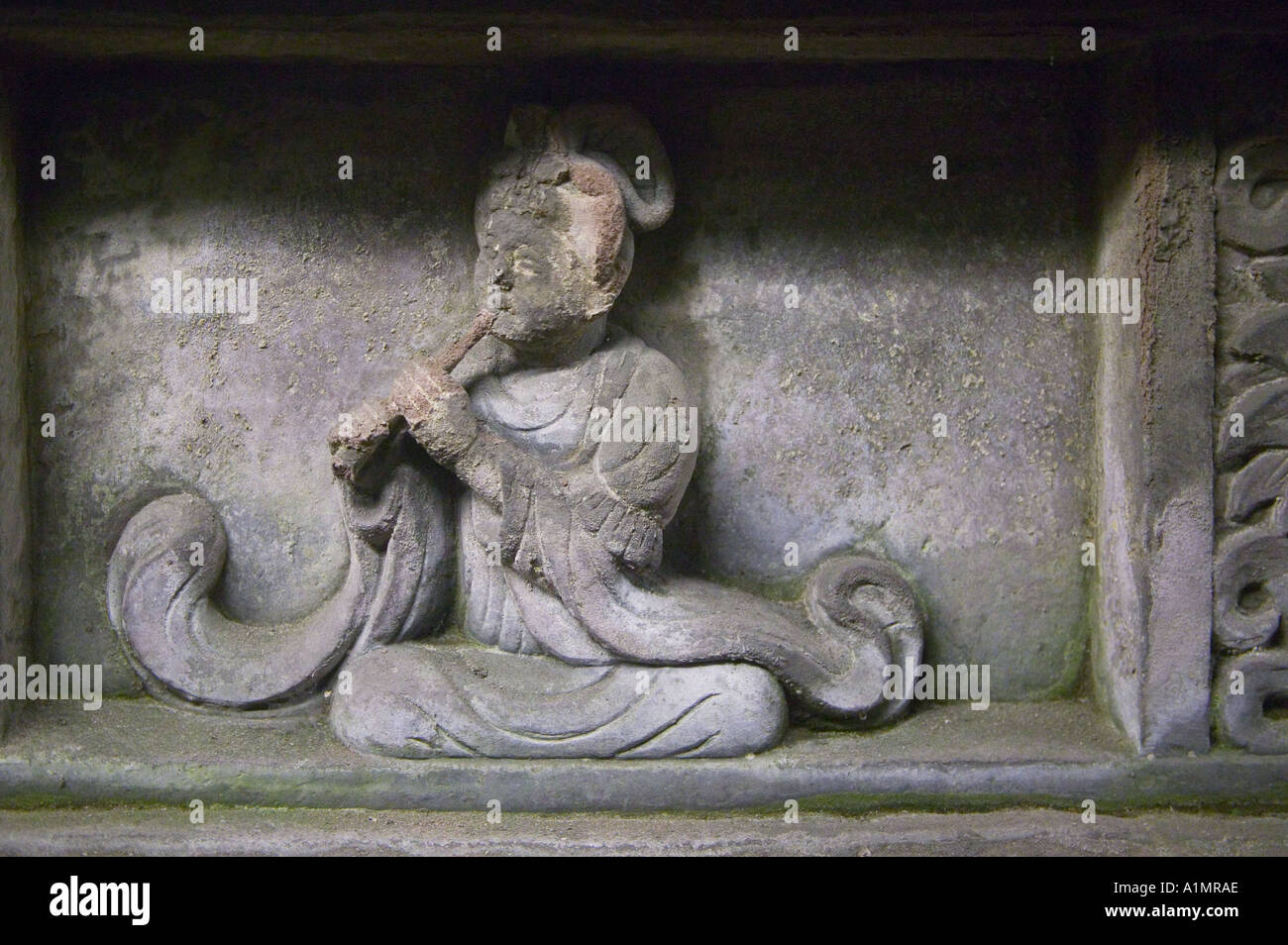 Carved figure of female musician holding traditional Chinese flute instrument Grand Bili in Yong Ling Tomb Chengdu Sichuan China Stock Photo