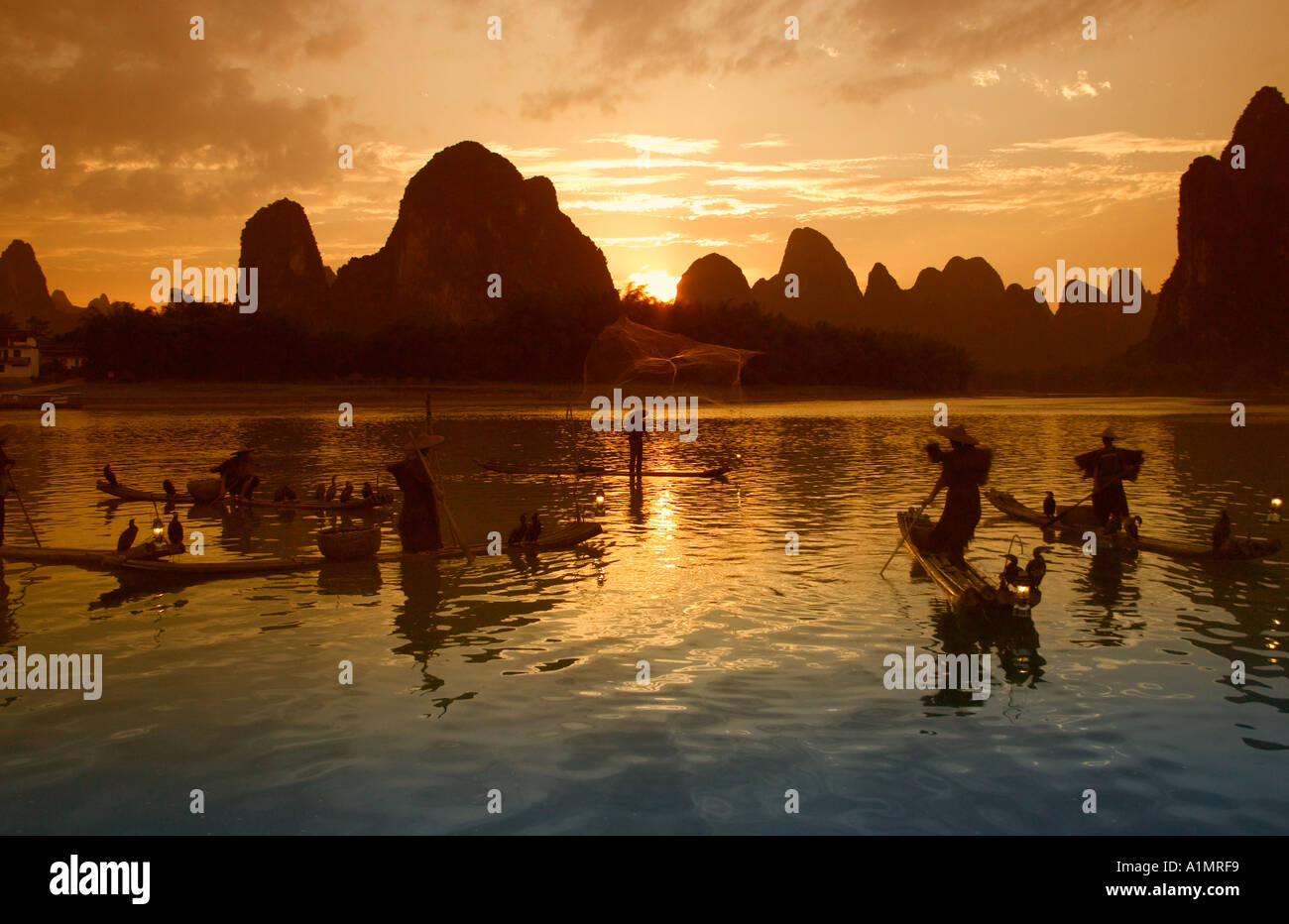 Fishermen on bamboo rafts on Li River at sunset Guangxi Province China Stock Photo