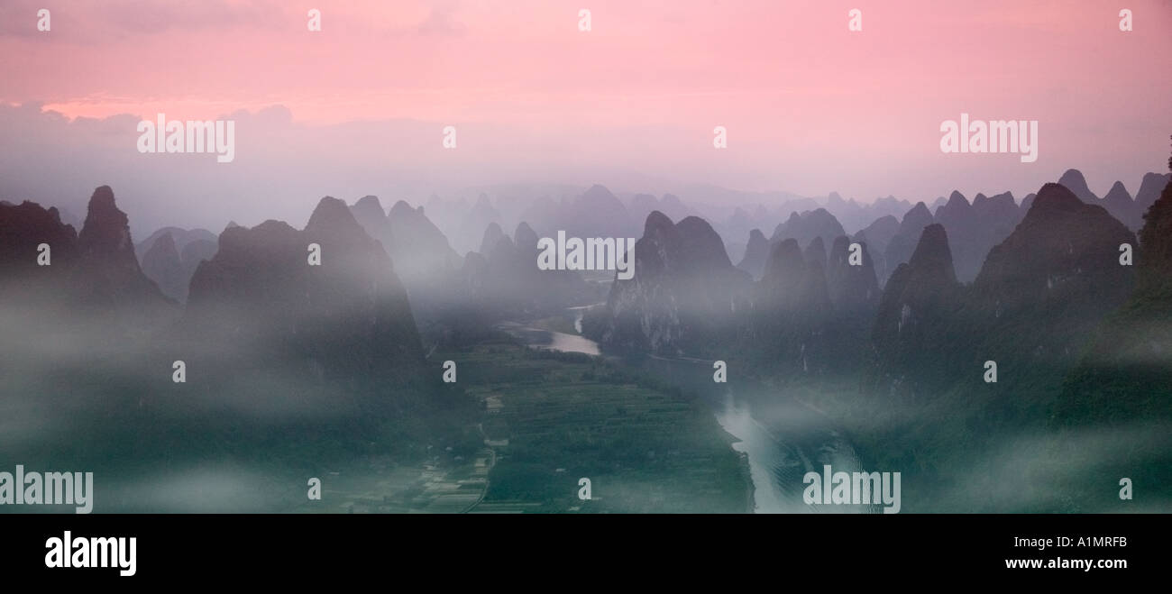 Li River winding through karst hills in early morning mist Yangshuo Guangxi Province China  Stock Photo