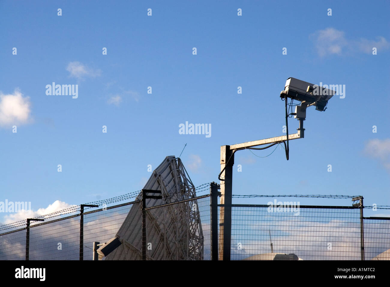satellite dish pointing skywards with cctv camera in foreground Stock