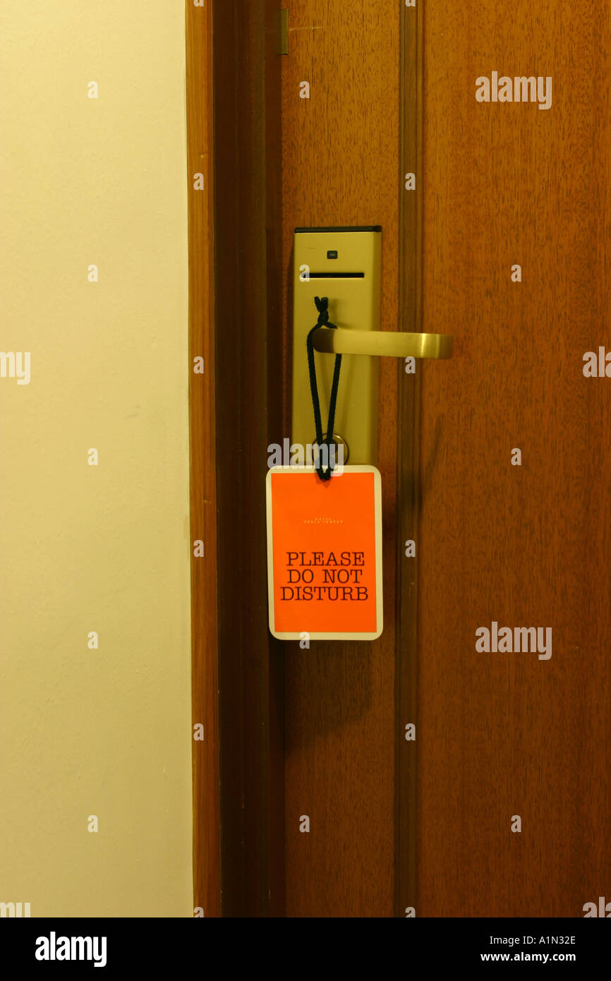 Do not disturb sign hanging from a hotel room door handle Stock Photo