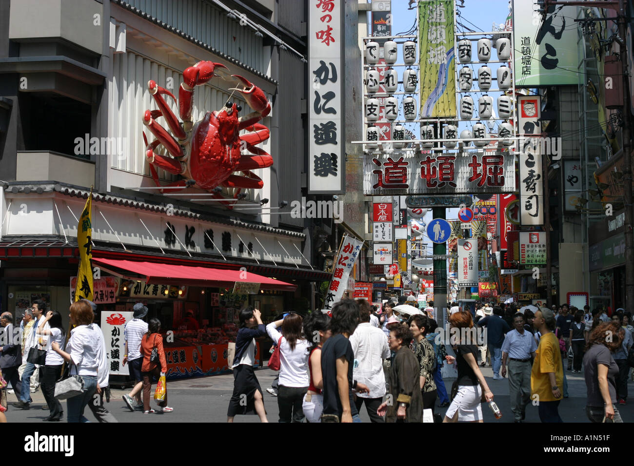 Japanese people and tourists walk through Dotonbori central Osaka in the  heat of summer under the famous crab restaurant Stock Photo - Alamy