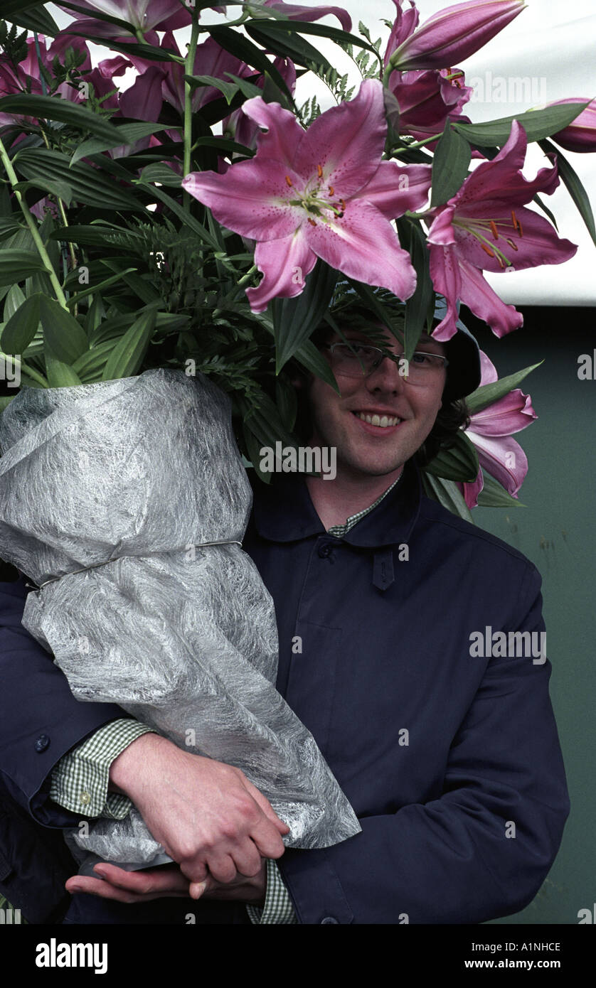 Man holding large pot of pink Lilies humour Last day at Chelsea show Stock Photo