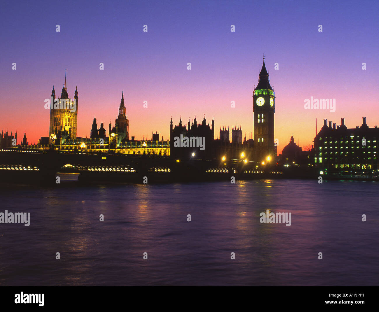 Houses of Parliament at night from across Thames, London, England UK Stock Photo