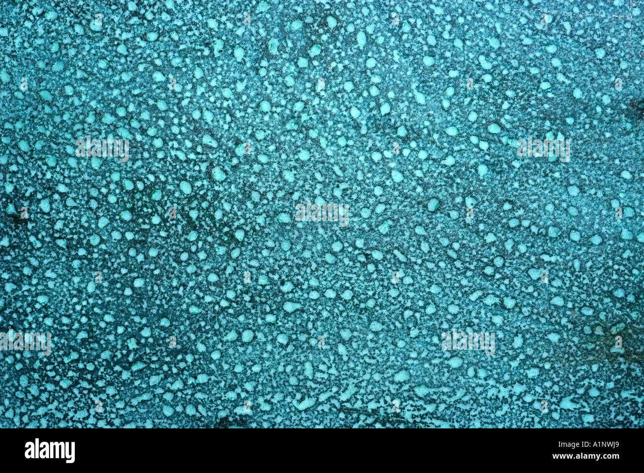 surface of a pitted bronze sculpture showing a blue patina Stock Photo