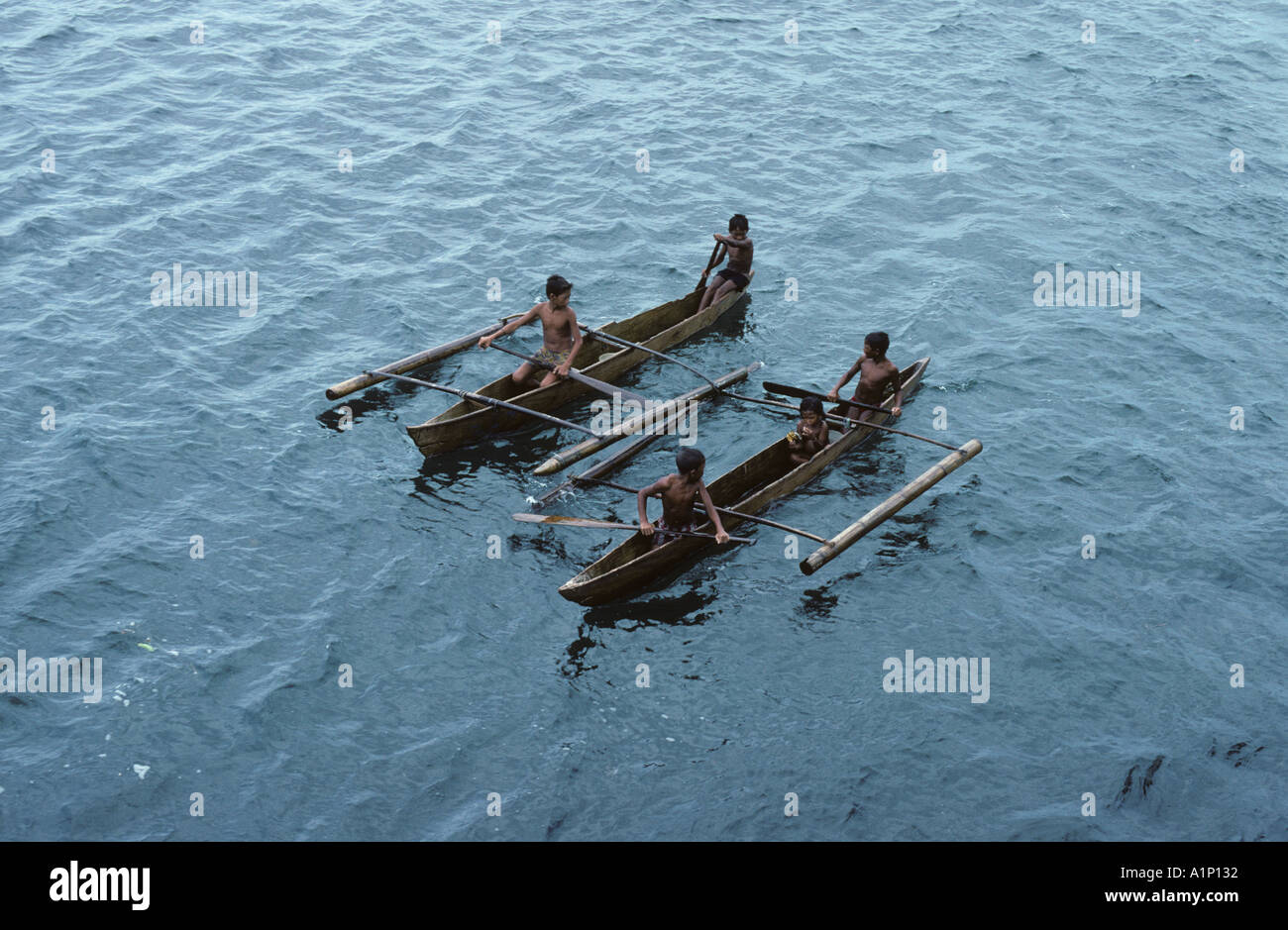 Badjao Badjau or Tau Laut sea gypsies Children Basilan Island Mindanao Philippines In outrigger canoe Dive for coins in water Stock Photo