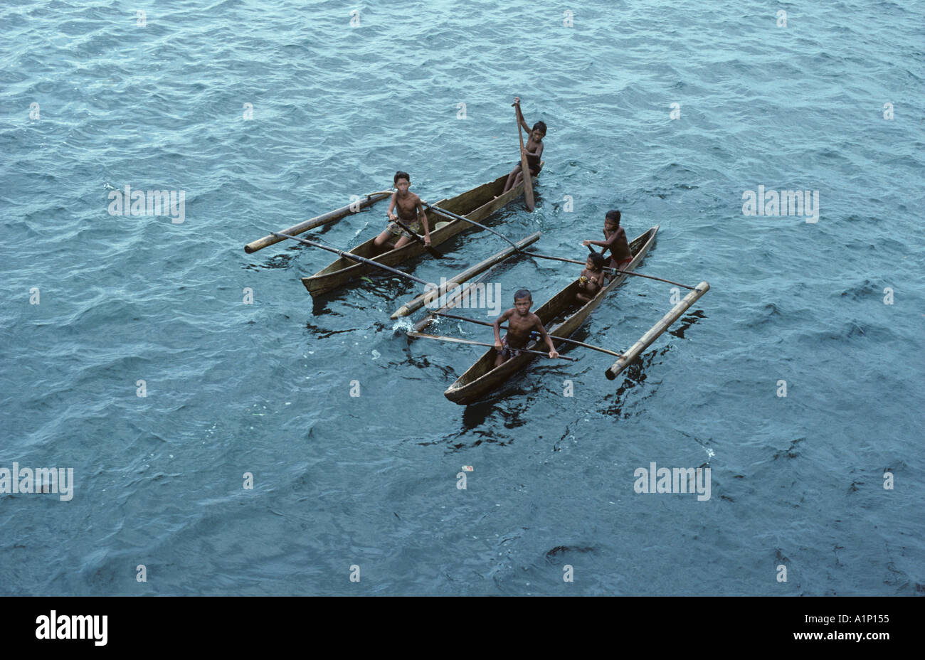 Badjao Badjau or Tau Laut sea gypsies children Basilan Island Mindanao Philippines In outrigger canoe Dive for coins in water Stock Photo