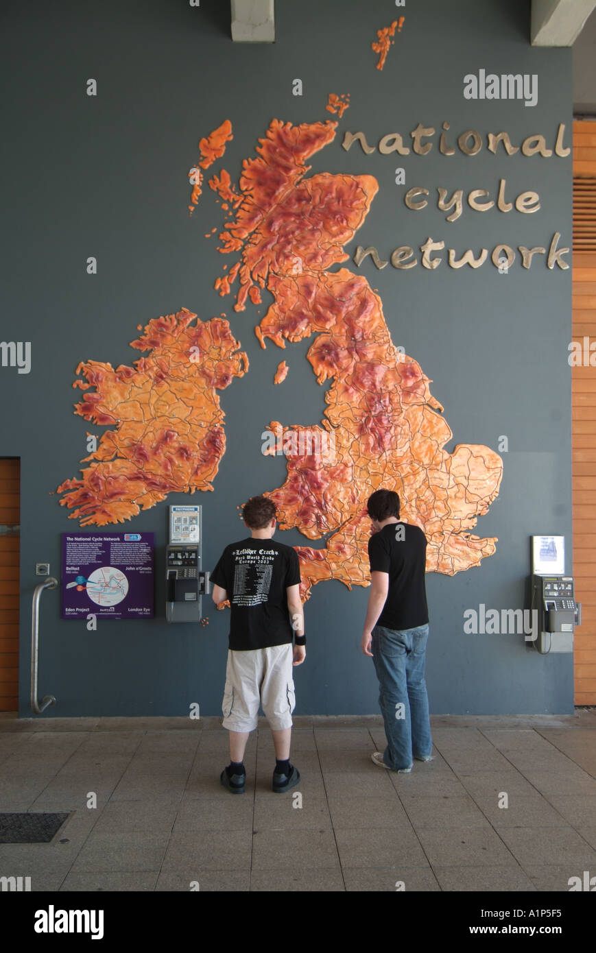 Bristol map on wall of the UK national cycle network with 2 two youngsters and adjacent telephone call boxes Stock Photo