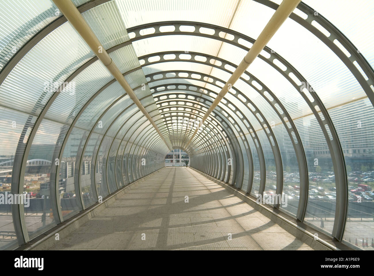 Pedestrian footbridge inside translucent steel framed tubular tunnel ...