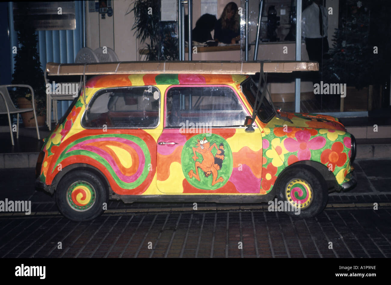 West End of London parked brightly decorated funky artwork paint job on iconic Mini motor car England UK Stock Photo