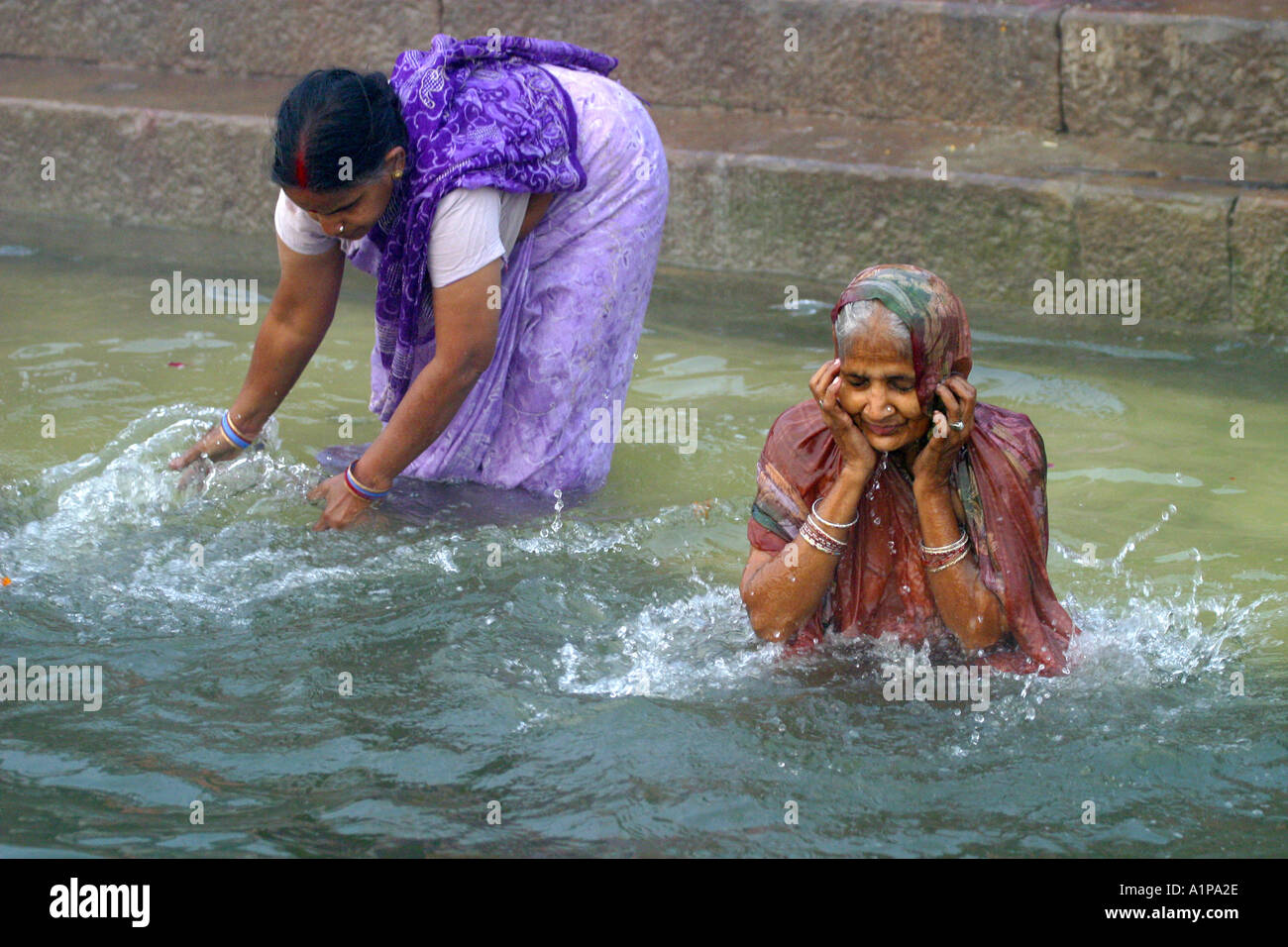Women take a religious bath to clean their souls from past sins in the holy  river Ganges in the city of Varanasi in northern Ind Stock Photo - Alamy