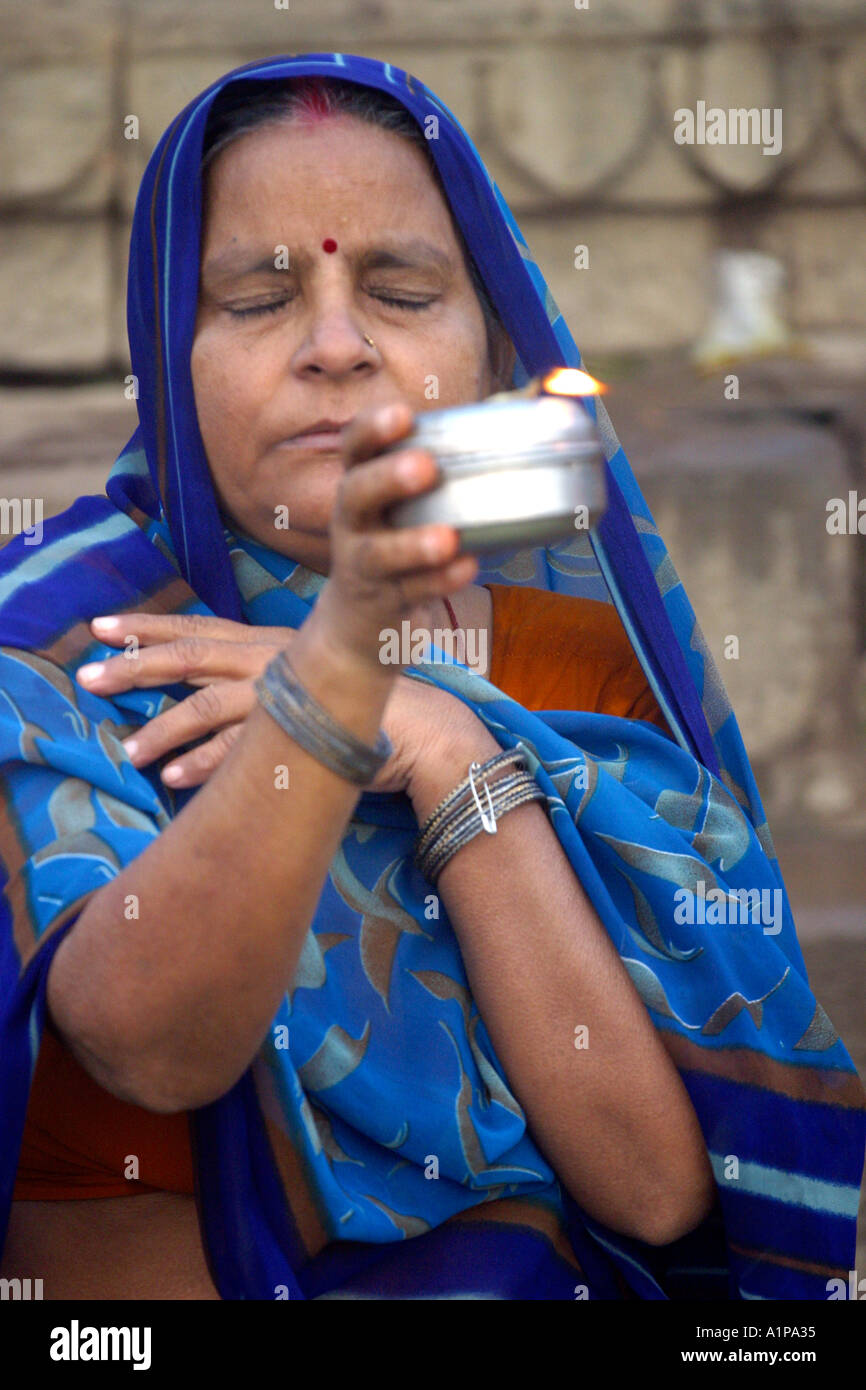A woman is performing a religious ritual on the banks of the Ganges in ...