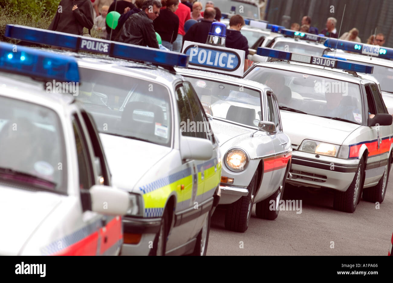 A line up of old fashioned police cars at a public event Stock Photo