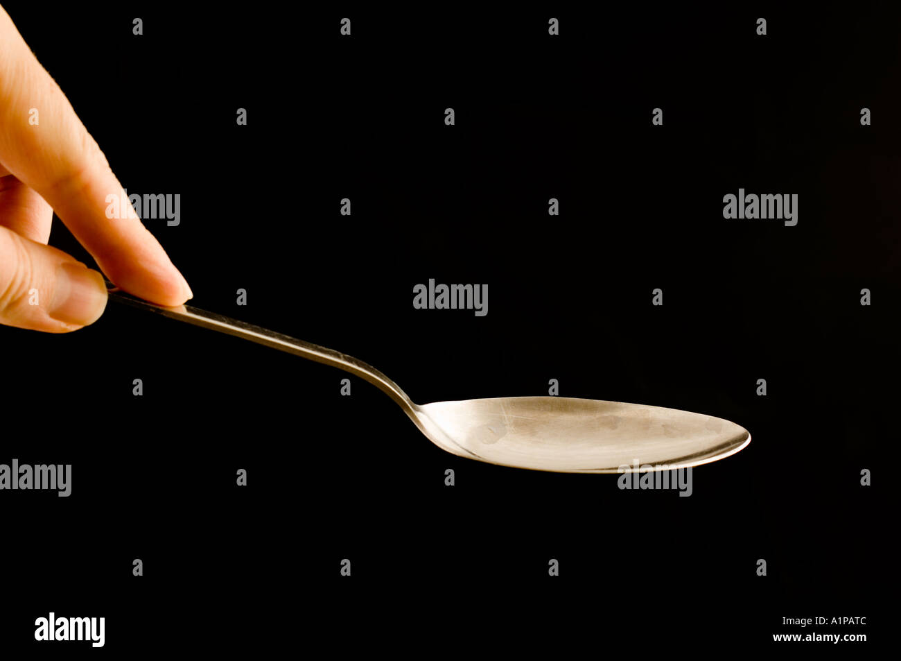 hand holding a large tablespoon Stock Photo Alamy