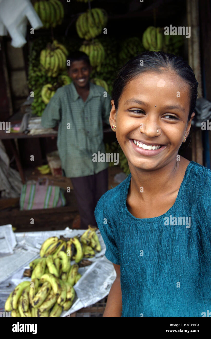 A girl near a street stall selling bananas in the town of Mapusa in Goa in India Stock Photo