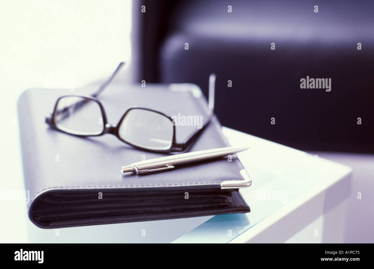 Spectacles and diary on table Stock Photo