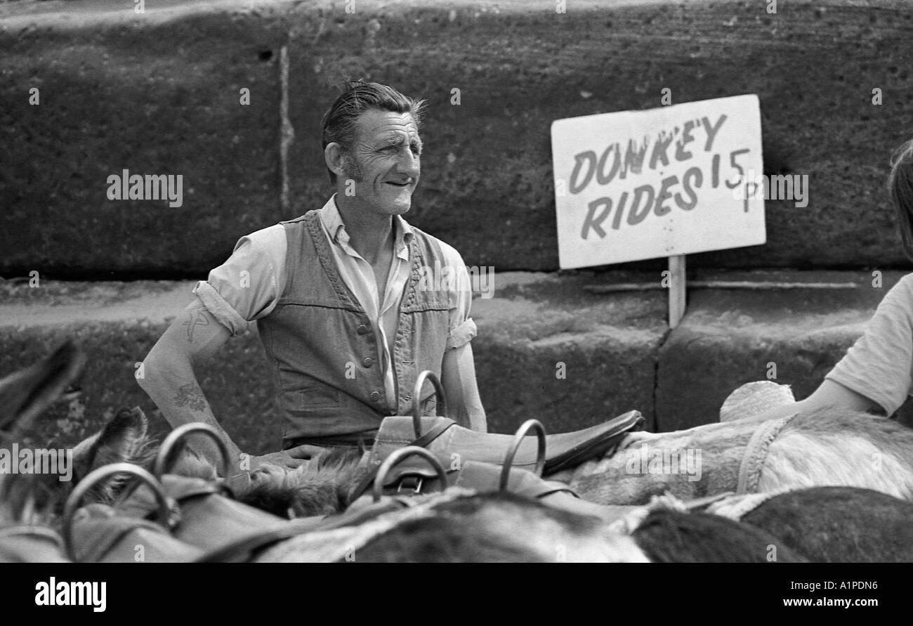Man on a beach selling rides on donkeys in 1970. Stock Photo