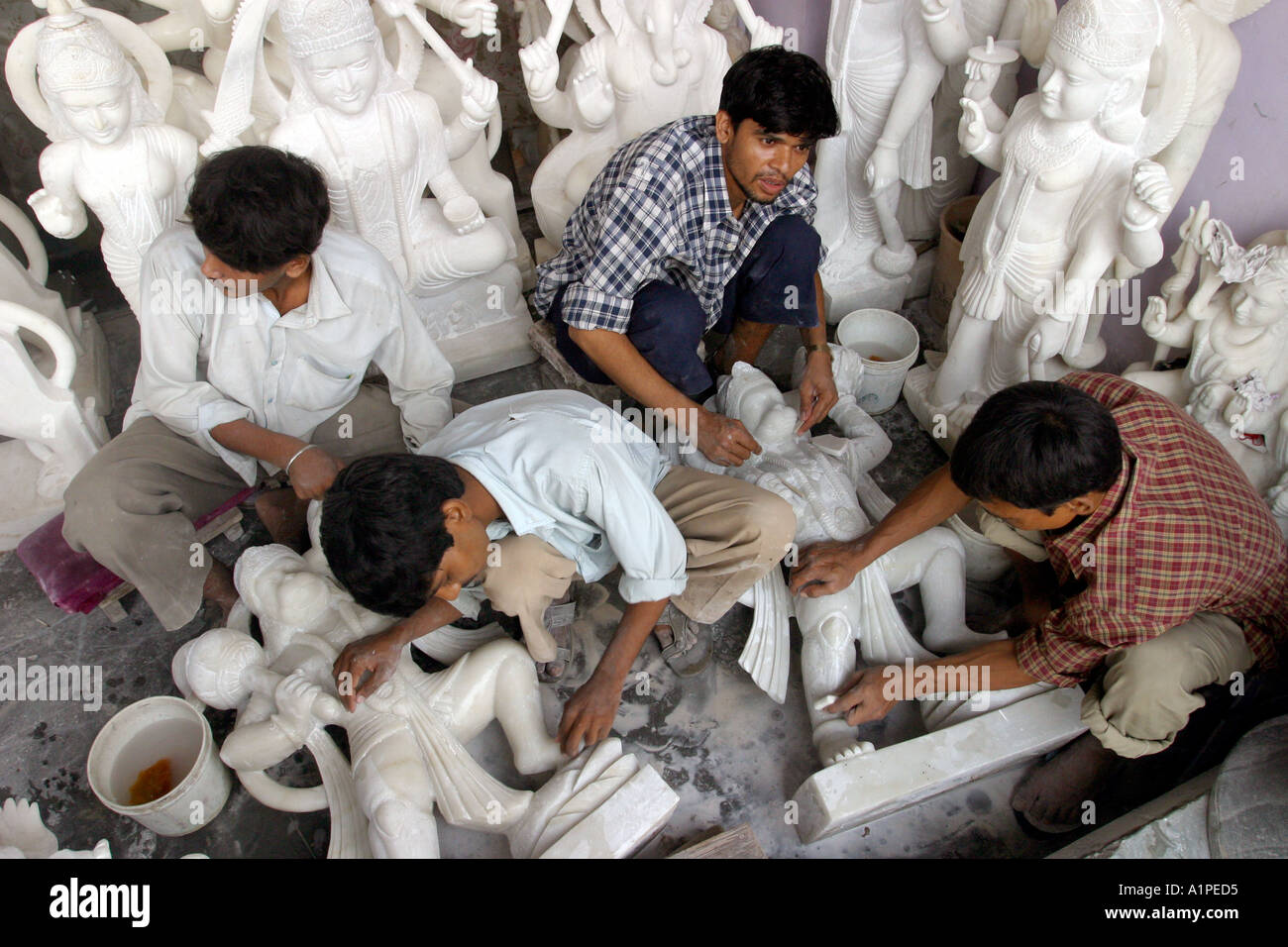 Sculpturers carve religious statues in a in New Delhi in India