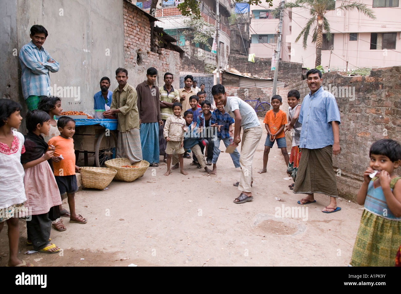 Neighborhood kids play cricket in the street in Dhaka Bangladesh Stock Photo