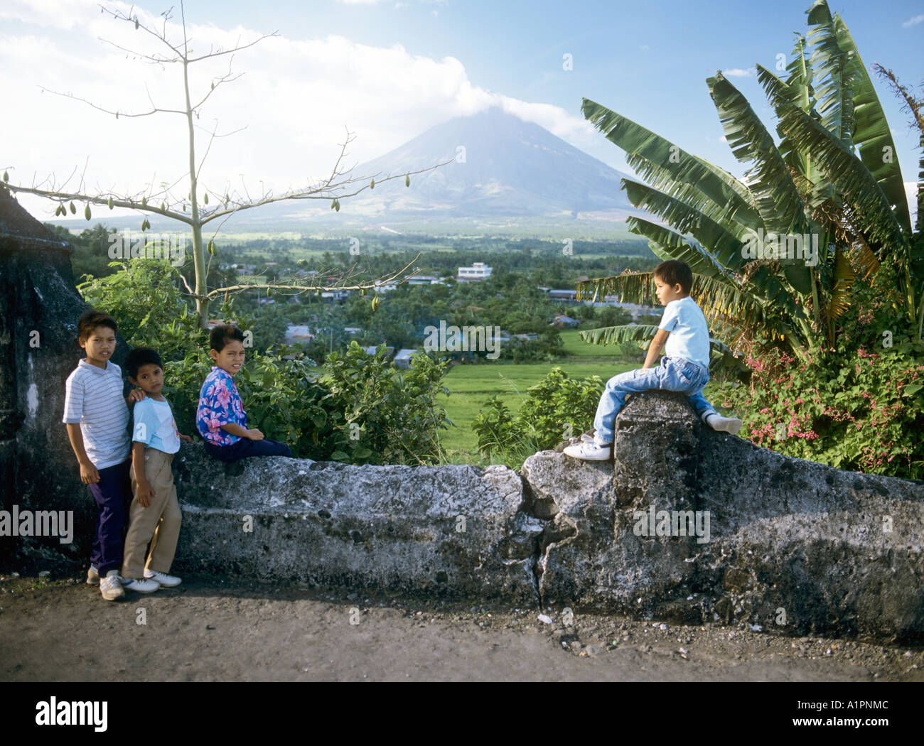 Local Filipino Children pose in front of the Mayon Volcano, Bicol, Philippines. Stock Photo