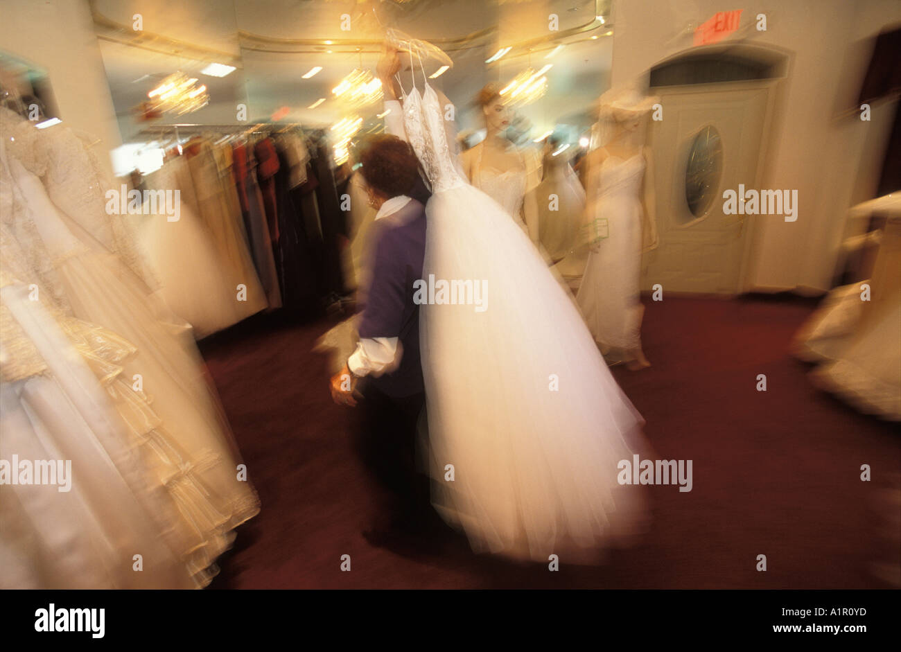 An employee of A Little White Wedding Chapel  in Las Vegas Nevada USA moves one of their  wedding gowns Stock Photo