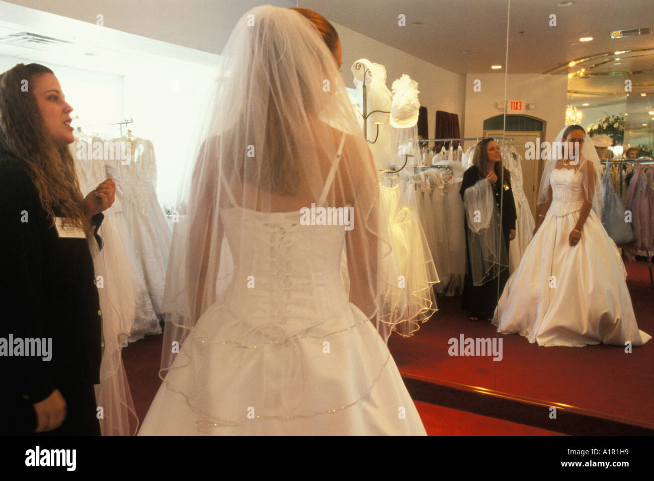 An employee at A Little White Wedding Chapel  in Las Vegas Nevada USA helps a bride select  her wedding gown Stock Photo
