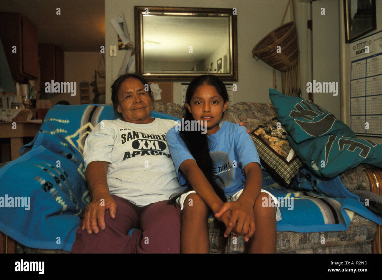 An Apache girl sits together with her  grandmother in their living-room on the San  Carlos Apache Indian Reservation Arizona USA Stock Photo