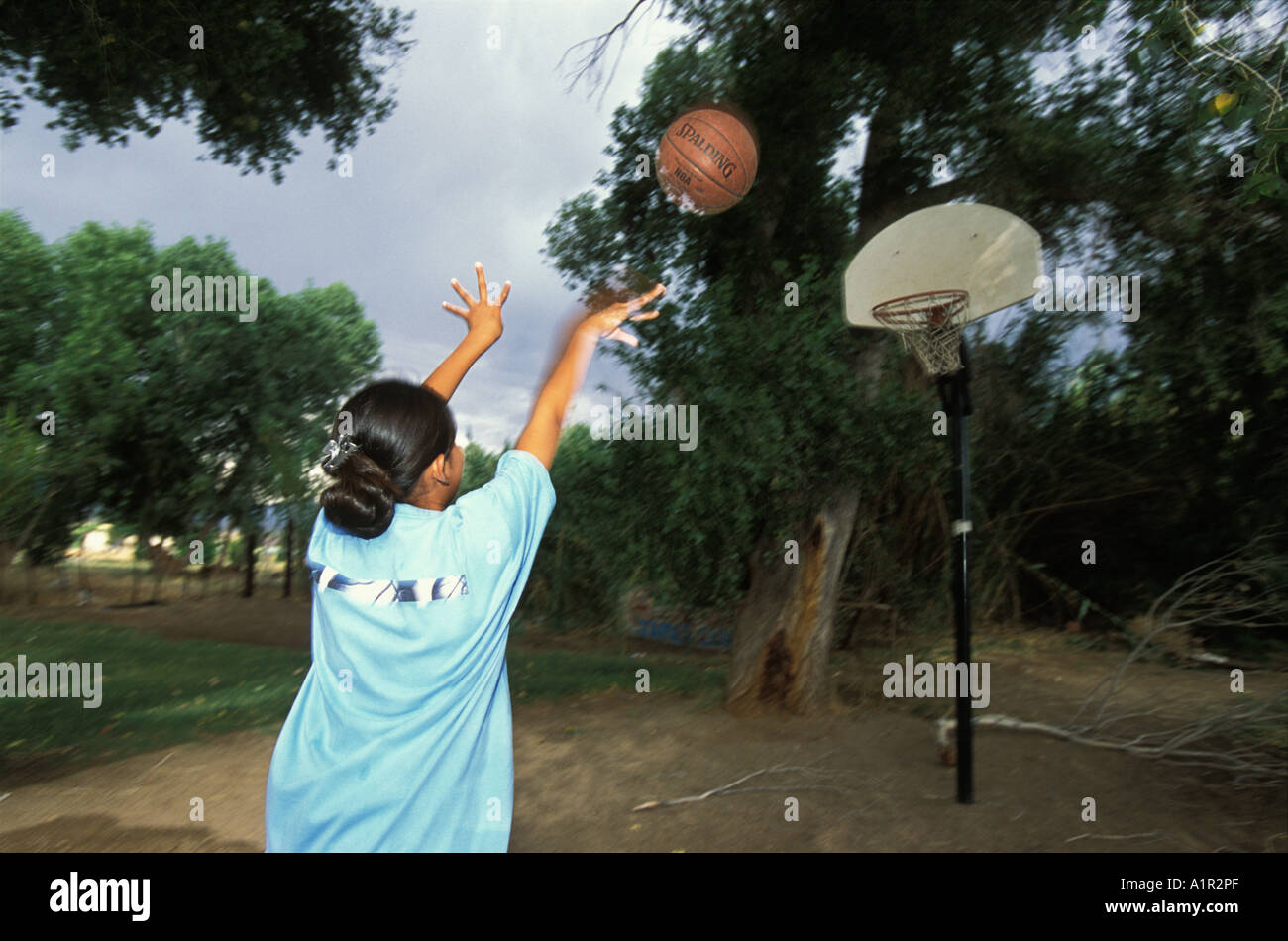 An Apache girl plays basketball in the back yard  of her home in Bylas the San Carlos Indian  Reservation Arizona USA Stock Photo