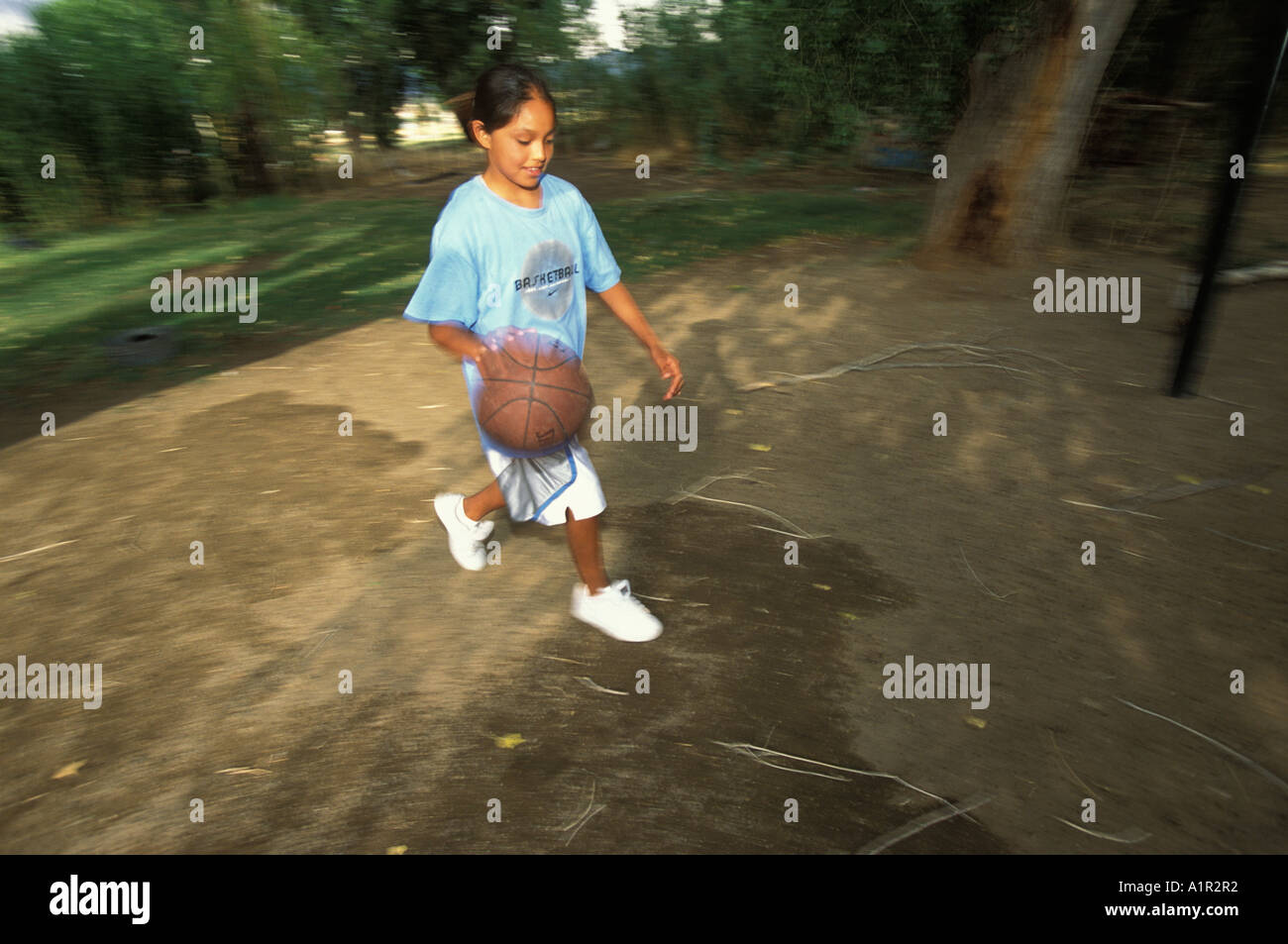 An Apache girl plays basketball in the back yard  of her home in Bylas the San Carlos Indian  Reservation Arizona USA Stock Photo