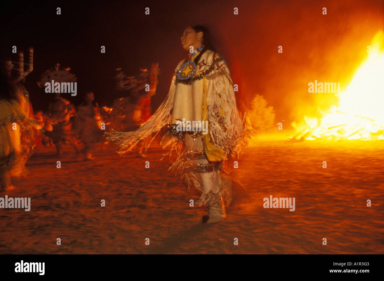 Apache girl and mountain spirits dance beside a bonfire at a Sunrise Dance on the San Carlos Reservation Arizona USA Stock Photo