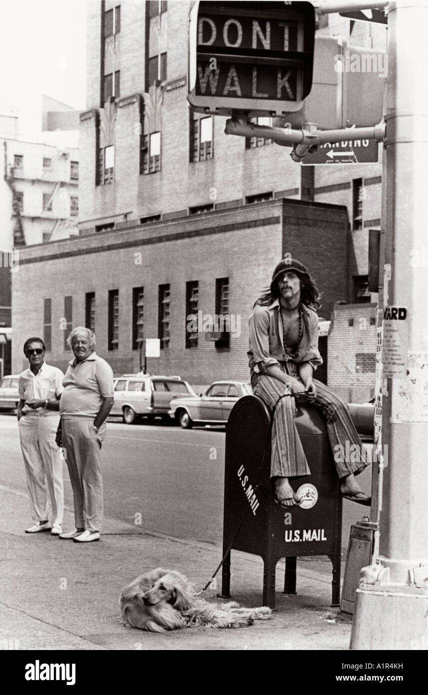 Hippy sitting on US mail box with stuffy older people watching Stock Photo