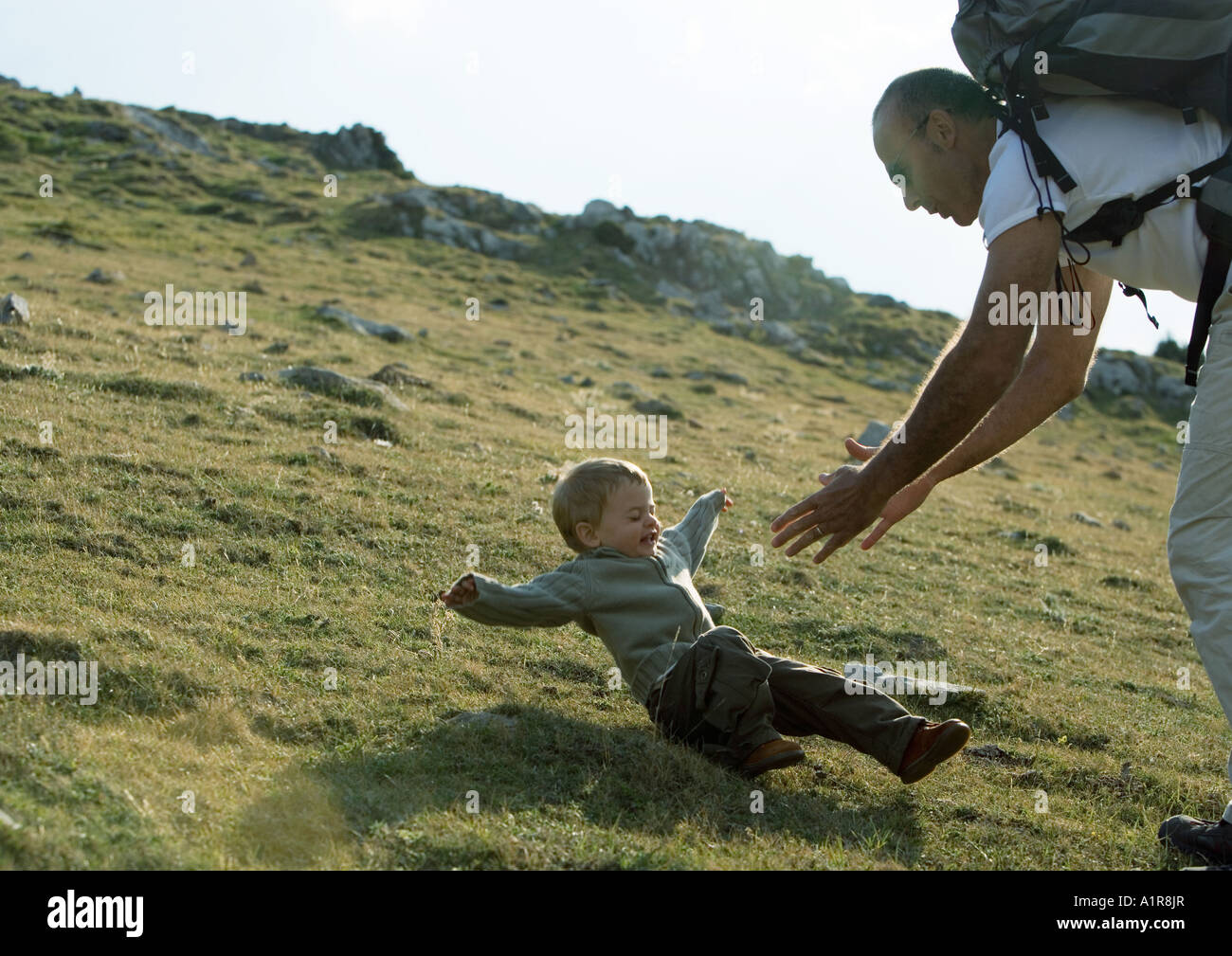 Boy falling as father reaches for him Stock Photo