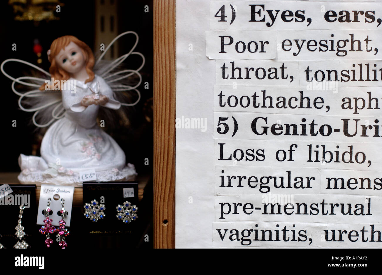 Angel doll and jewelery with sign detail in Chinese herbalist shop window Stock Photo