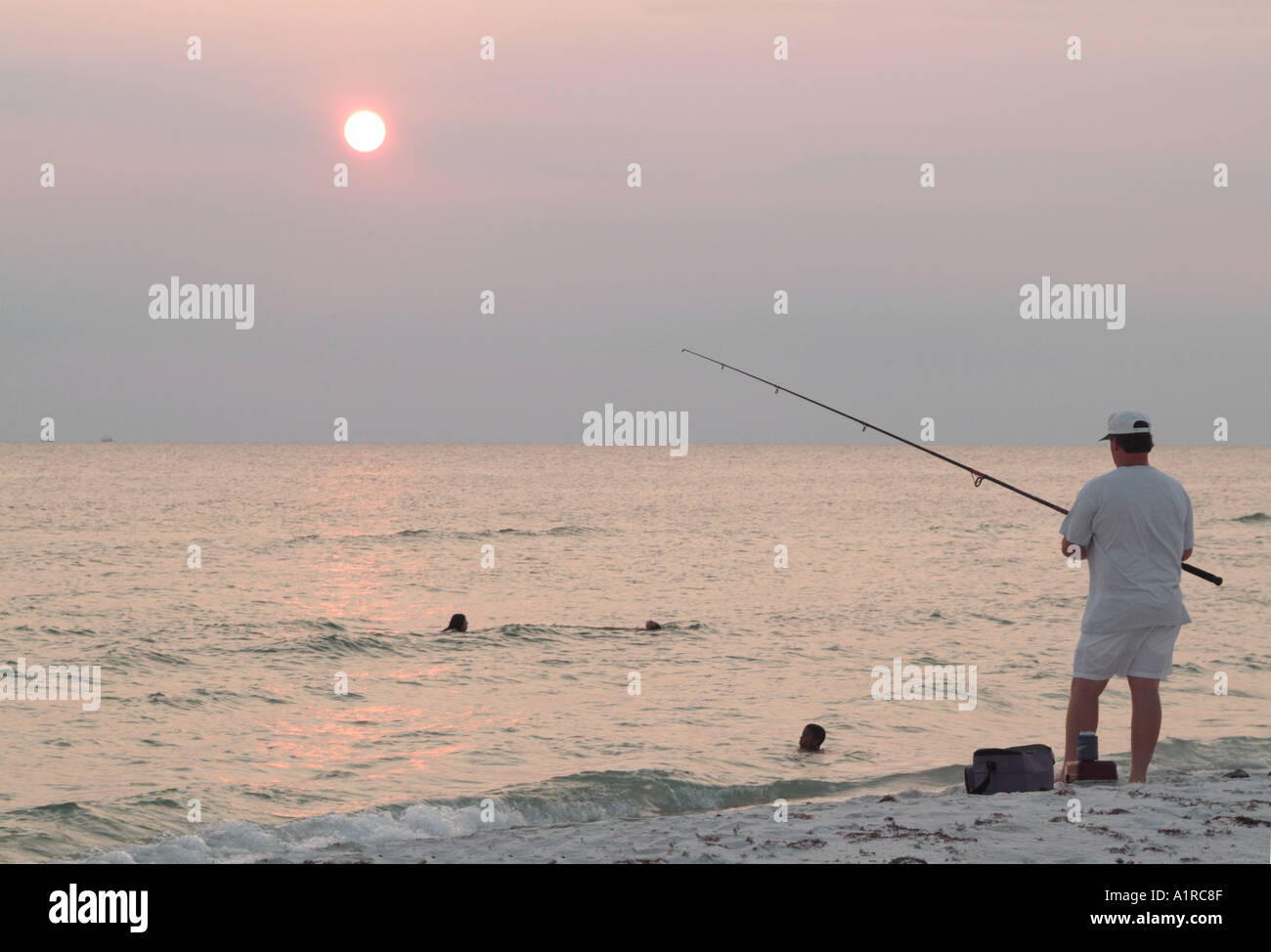 Surf fisherman and bathers at sunset St Joseph's Peninsula State Park FL Stock Photo