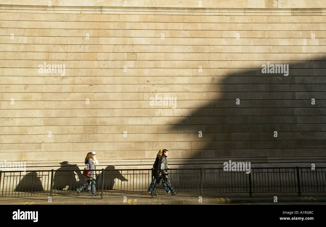 people in shadows walking past west wall of bank of england Stock Photo
