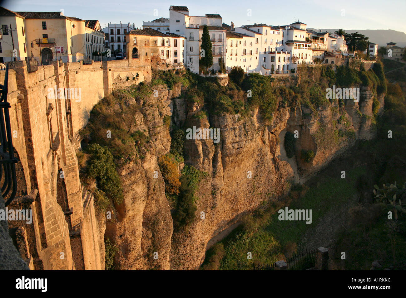 The old town of Ronda perched high above the gorge on warm red cliff lit by a late afternoon sun Ronda Andalucia Spain Stock Photo