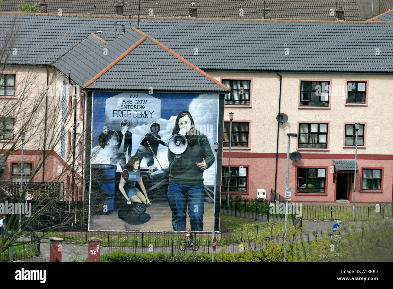 Bernadette from the Wall. A huge bogside mural of a protester with a megaphone dominates the side of a council flat. Stock Photo