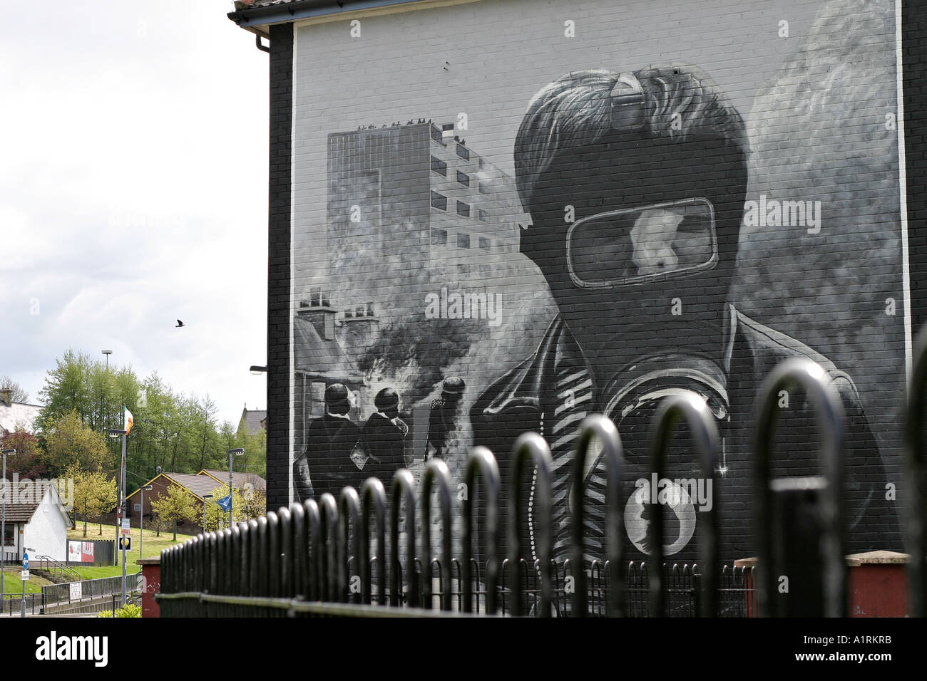 A view along a steel fence toward a detail of the bogside mural The Petrol Bomber Londonderry Derry Northern Ireland UK Stock Photo