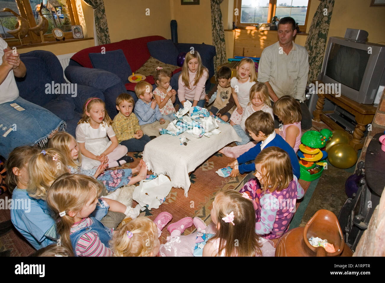 Young children playing pass the parcel game at birthday party UK Stock