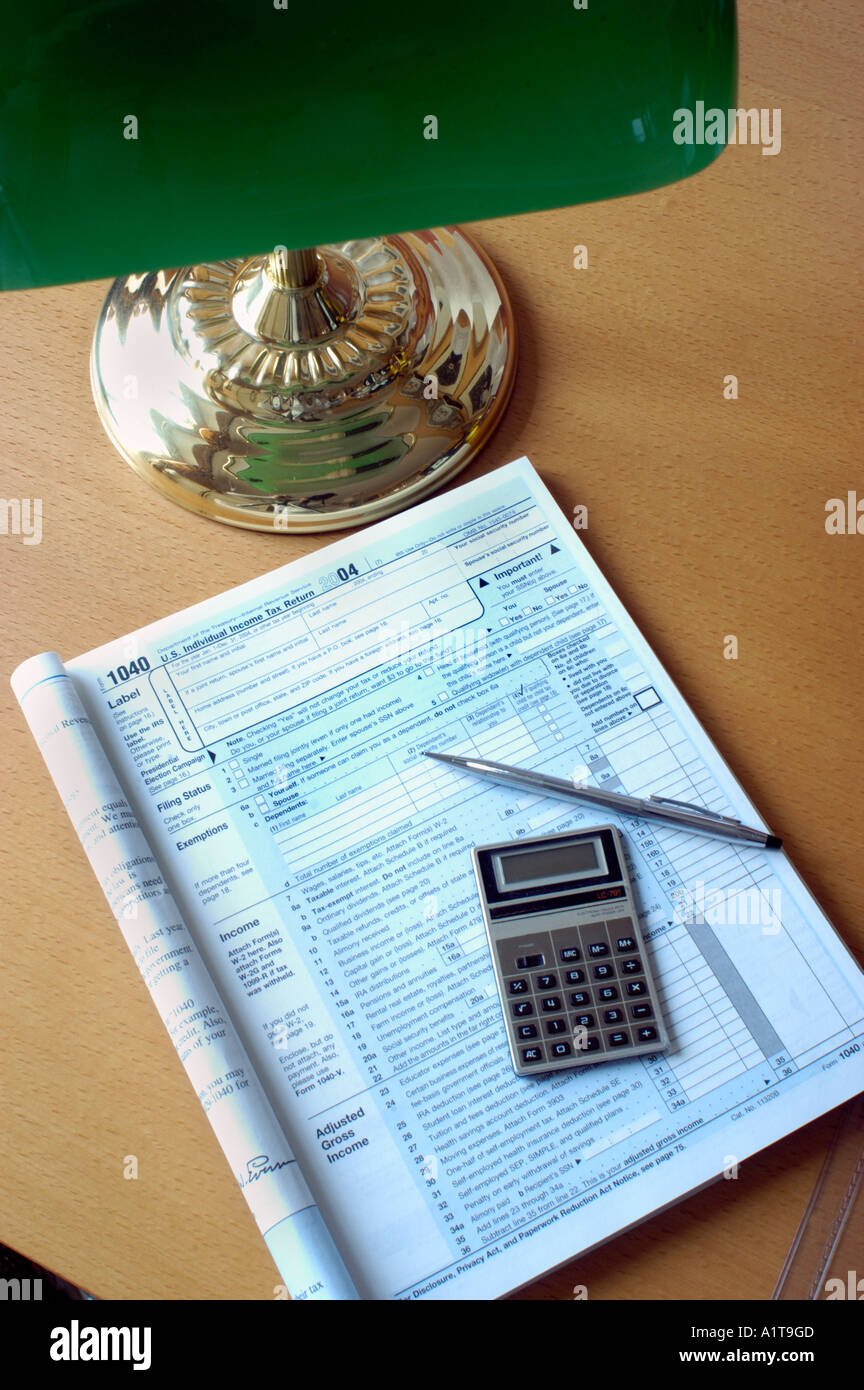 High Angle, Detail, American 'Income Tax Form 1040' Ready to be Filled Out on 'Desk lamp' Calculator Stock Photo