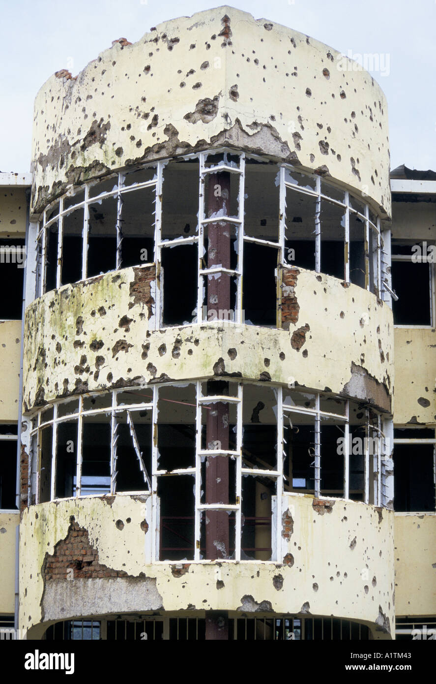 DAMAGED BUILDING, ITS WINDOWS SHATTERED, OUTER WALLS PITTED BY MACHINE GUN BULLET MARKS AND SHELLFIRE IN KIGALI Stock Photo