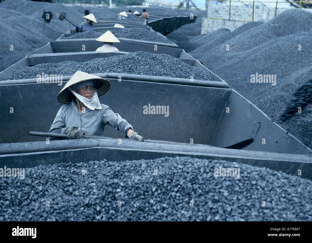 VIETNAM. Women unload coal from railway trucks. Stock Photo
