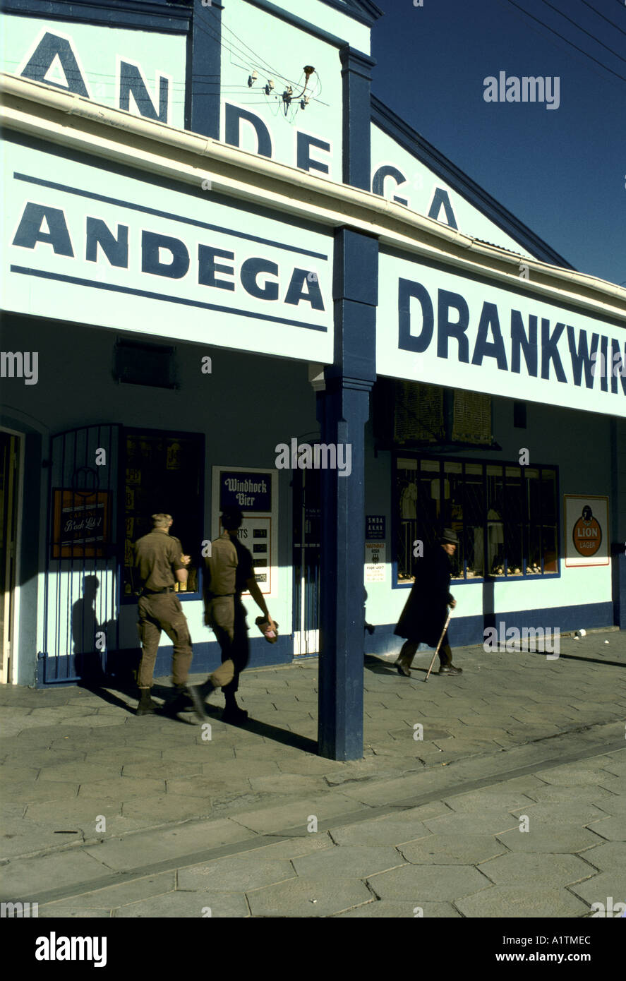 LOCAL STORE NAMIBIA with men walking in shadows and writing in Afrikaans Stock Photo