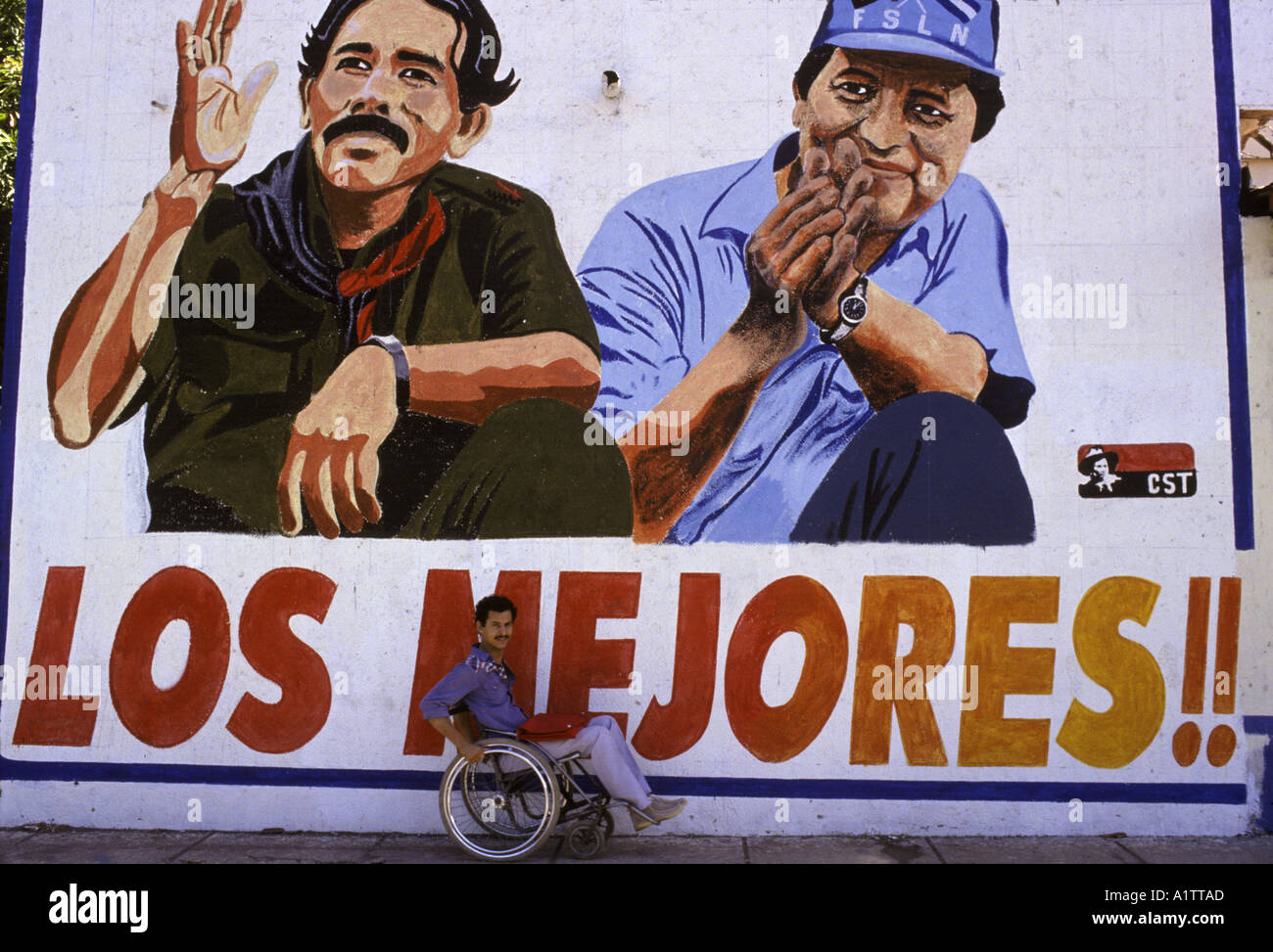 Man in wheelchair in front of mural FOR NICARAGUAN ELECTIONS , showing pictures of Daniel Ortega and Sergio Ramirez 1990 Stock Photo