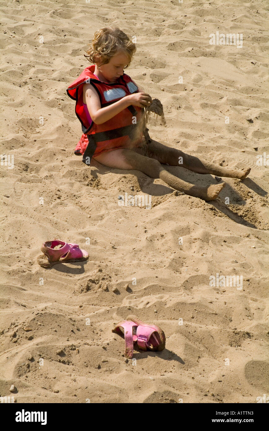 Little girl playing in the sand Stock Photo