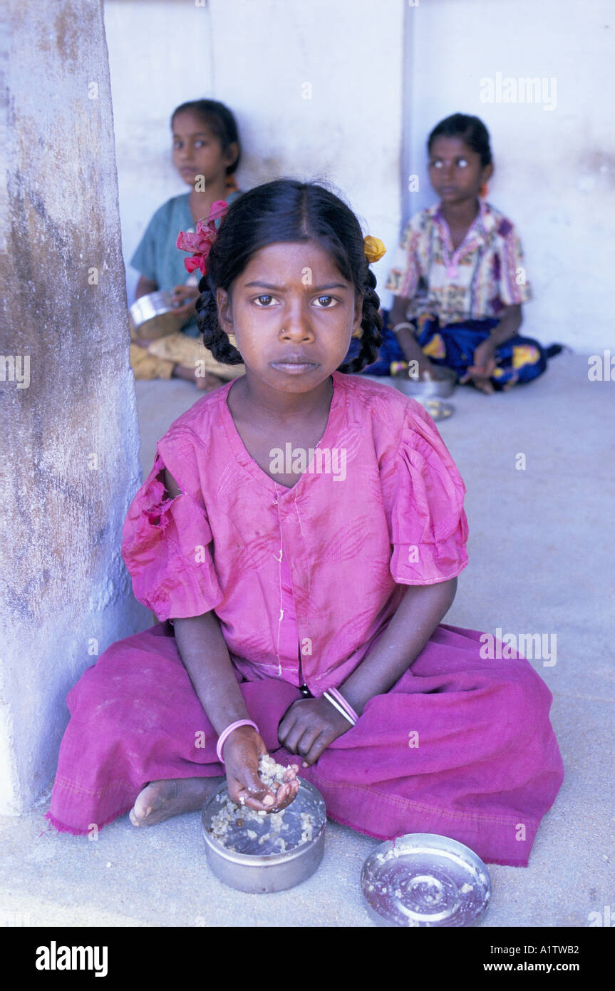 INDIA TAMIL NADU. THREE YOUNG GIRLS EATING THEIR SCHOOL LUNCH FROM METAL TIFFEN TINS.1996 Stock Photo