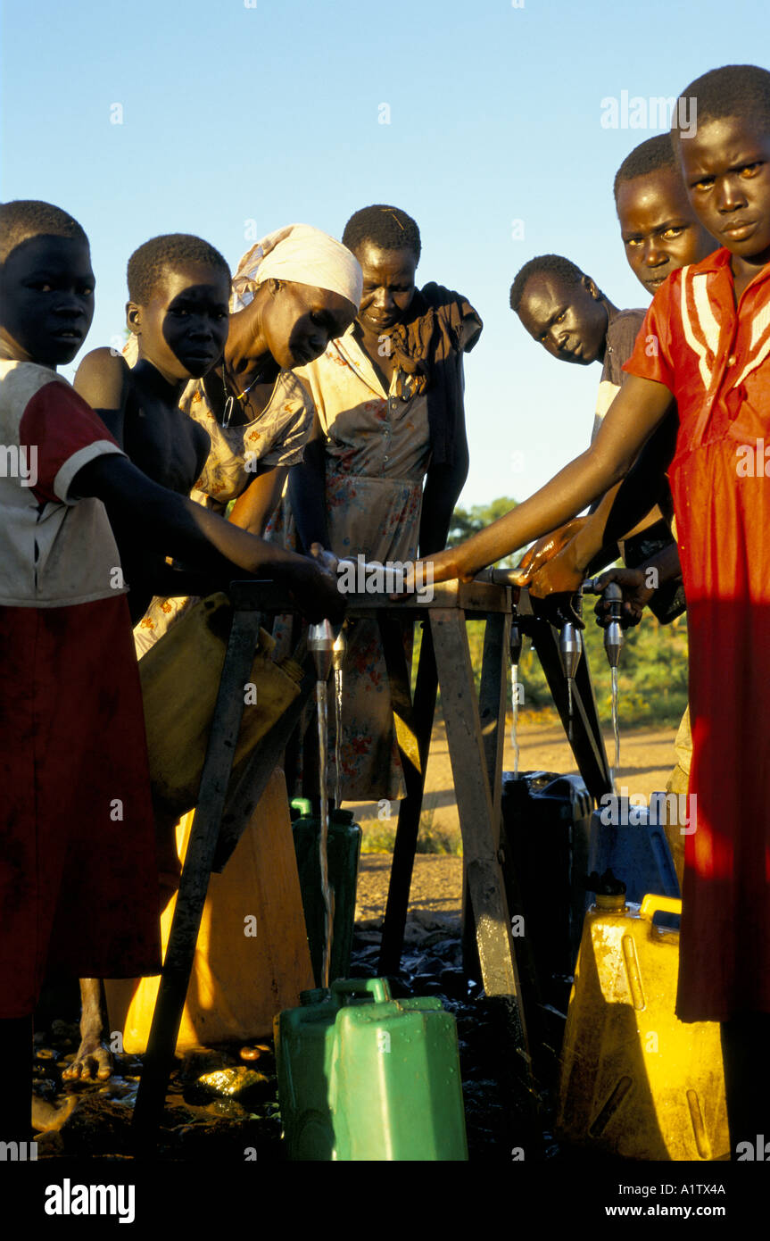 SUDANESE REFUGEES COLLECTING WATER IN PLASTIC CONTAINERS AT STAND PIPE