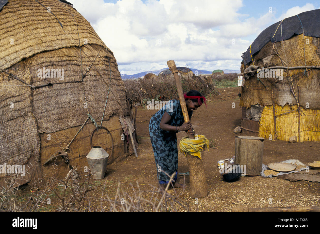 SOMALI REFUGEES JIJIGA ETHIOPIA WOMEN USING PESTLE AND MORTER OUTSIDE
