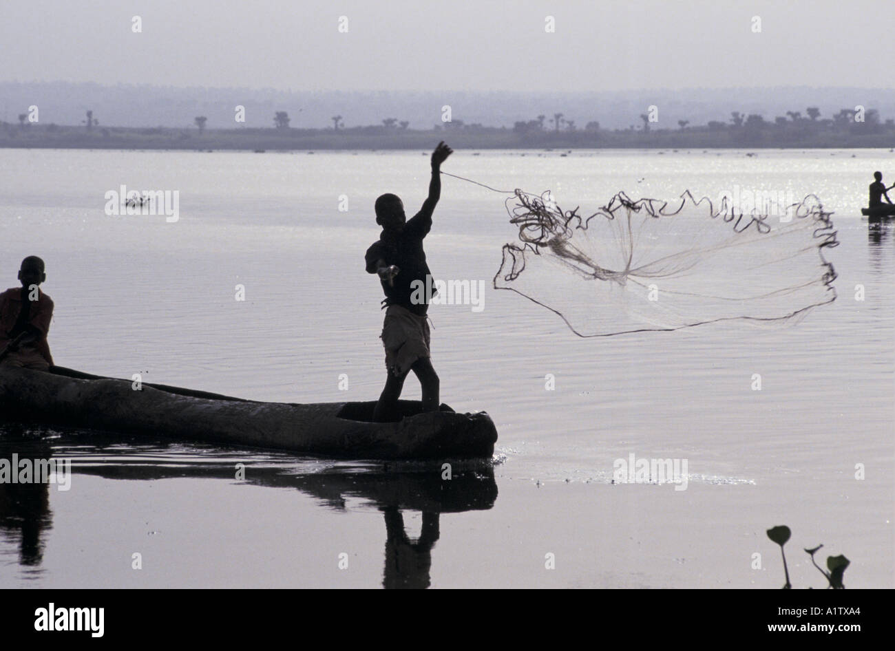 FISHING ON THE RIVER NILE UGANDA. Boy throwing a net Stock Photo - Alamy